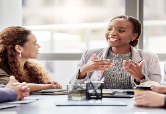 woman presenting at a meeting sitting at a table